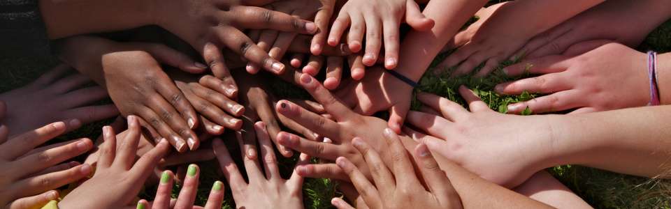 Group of children with their hands in the center